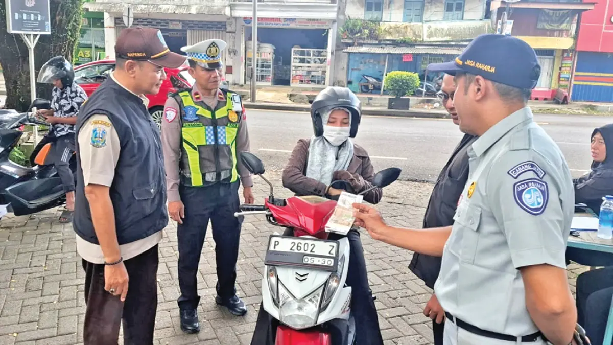 Petugas gabungan dari Unit Lantas Polsek Genteng, Badan Pendapatan Daerah (Bapenda) Banyuwangi, dan Jasa Raharja menggelar sosialisasi sekaligus operasi kepatuhan berkendara, Rabu (8/7). (Foto: Polsek Genteng)