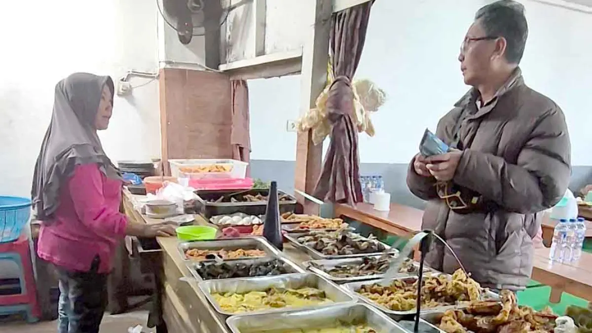 WARUNG LEGENDARIS: Salah satu pelanggan membeli makanan di Warung Sirot di Jalan Diponegoro nomor 245, Dusun Lidah, Desa/Kecamatan Gambiran. (Salis Ali/Radar Banyuwangi)
