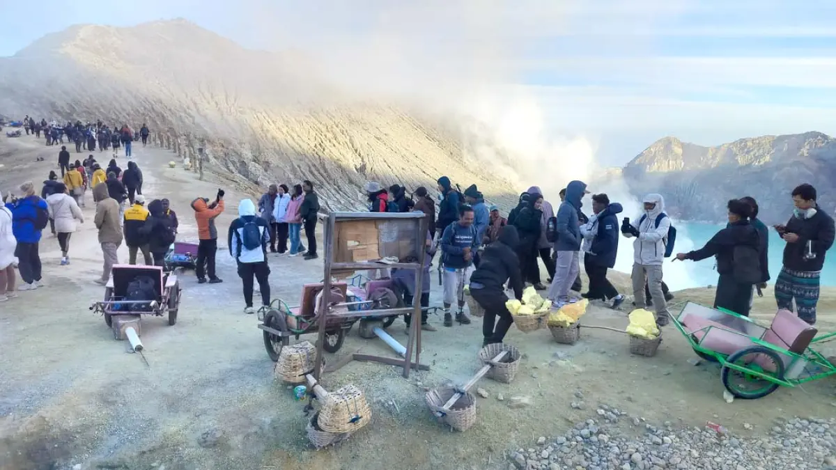 Wisatawan mancanegara dan domestik menikmati suasana pagi di puncak Ijen, Sabtu (11/7). Mereka bisa melihat kawah dan aktivitas penambang belerang. (Sugeng for Radar Banyuwangi)