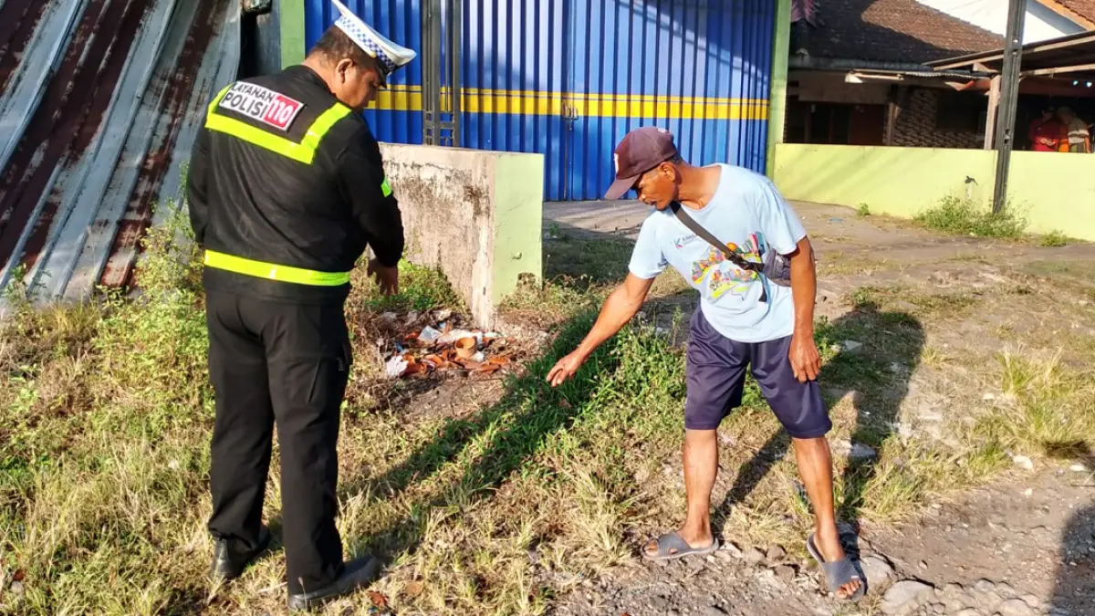 Petugas Polsek Genteng melakukan oleh tempat kejadian perkara temuan mayat di tepi jalan Dusun Krajan 2, Desa Kembiritan, Kecamatan Genteng, Minggu (12/7). (Sujarwadi for Radar Banyuwangi)