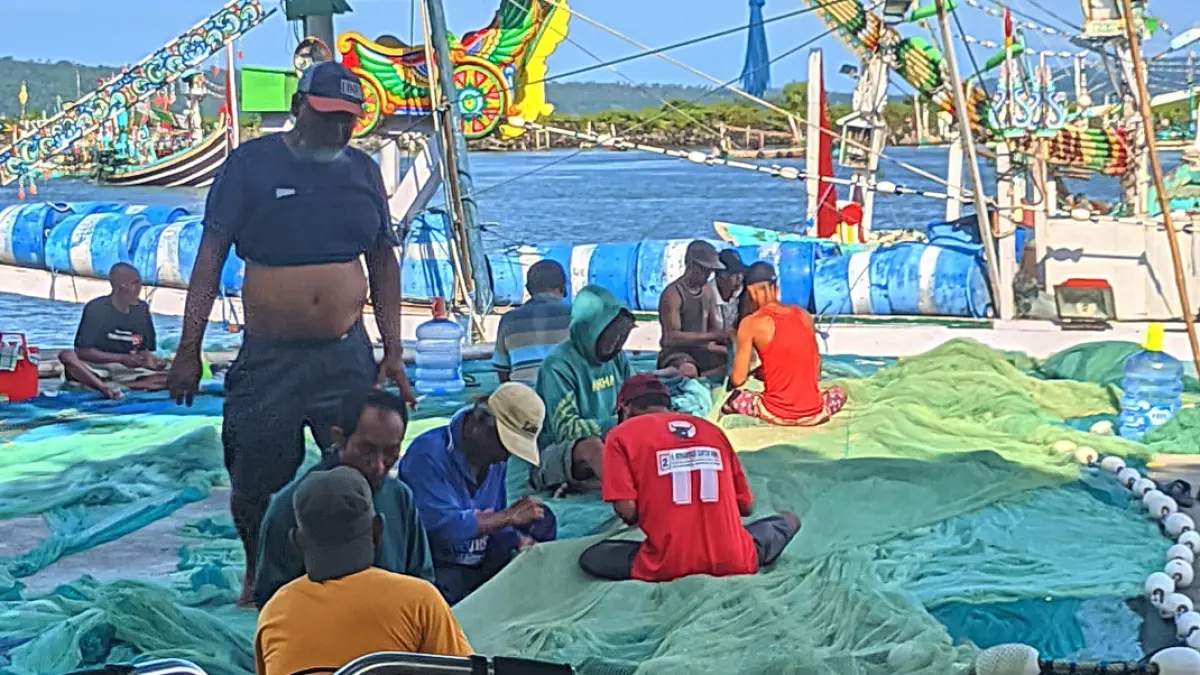 Nelayan memperbaiki jaring di kawasan pesisir Muncar beberapa waktu lalu. (Dok. Radar Banyuwangi)