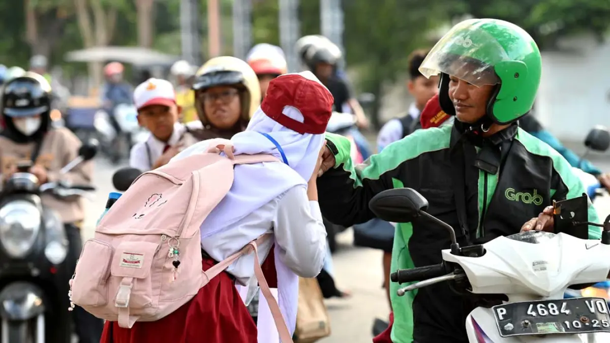 Siswa baru SMPN 1 Banyuwangi cium tangan orang tuanya sebelum memasuki halaman sekolah pada hari pertama MPLS, Senin (13/7). (Ramada Kusuma/Radar Banyuwangi)