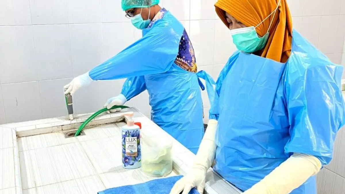 PROFESIONAL: Petugas menyiapkan perlengkapan yang diperlukan untuk pemulasaraan jenazah di RSUD Blambangan.(Putri RSUD Blambangan untuk Raba)