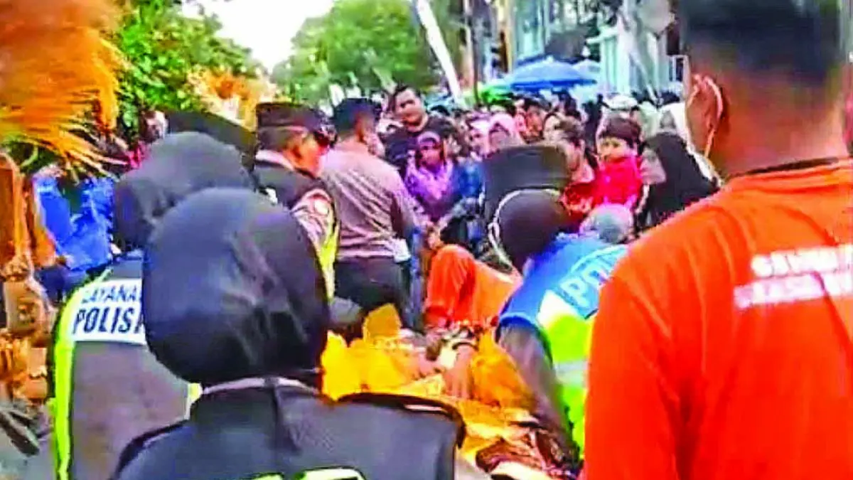 SIGAP-HUMANIS: Personel Polresta Banyuwangi mengevakuasi talent BEC yang pingsan saat parade pada Sabtu (18/7). (Humas Polresta Banyuwangi)