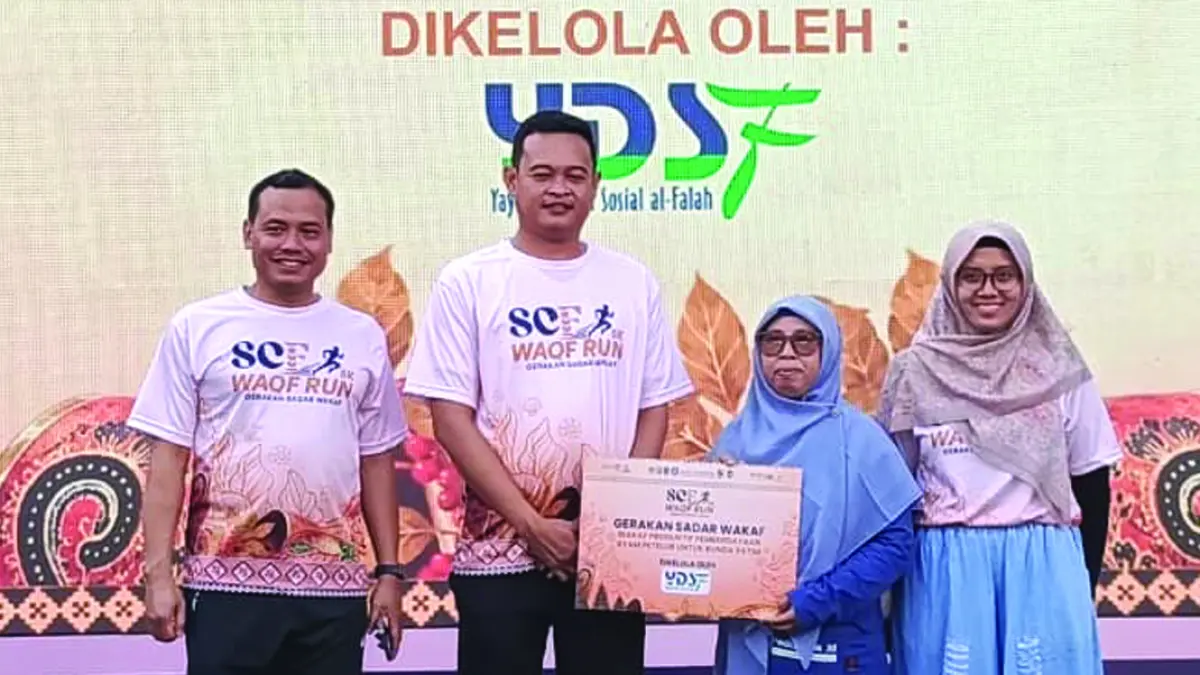 SIMBOLIS: Kepala KPw Bank Indonesia Jember Iqbal Reza Nugraha (dua dari kiri) didampingi Deputi Kepala KPw BI Jember Ahmad (kiri) menyerahkan hasil wakaf Run 5K kepada YDSF, Minggu (19/7). (Toha/Radar Banyuwangi)