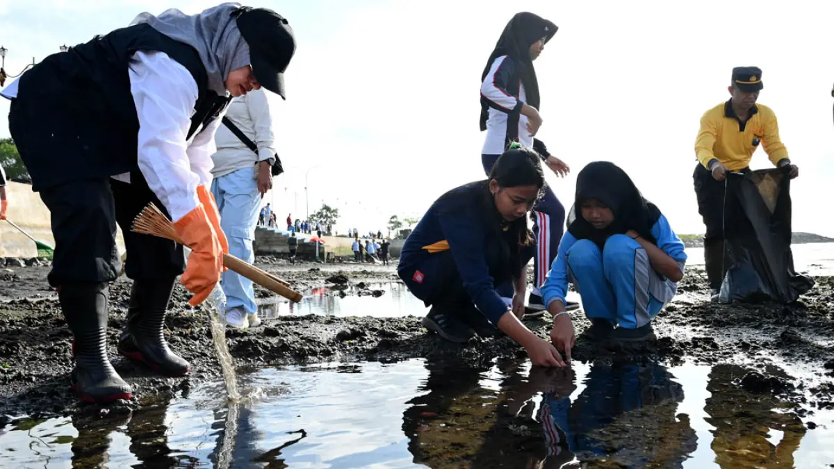 Bupati Ipuk Fiestiandani bersama sejumlah elemen masyarakat dan pelajar membersihkan sampah di pantai pesisir sekitar Kampung Nelayan Merah Putih, Kelurahan Lateng, Selasa (21/7). (Ramada Kusuma/Radar Banyuwangi)