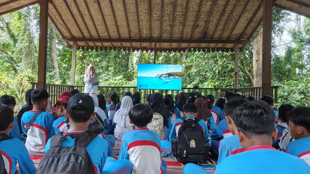 Puluhan siswa SDN 1 Rogojampi mendapatkan materi dari petugas PUDAM Banyuwangi Nadia Hidayanti Suseno saat mengikuti program Wis Esa Sek Adi di kawasan Sumber Gedor, Rabu (22/7). (Ksatria Raya/Radar Banyuwangi)