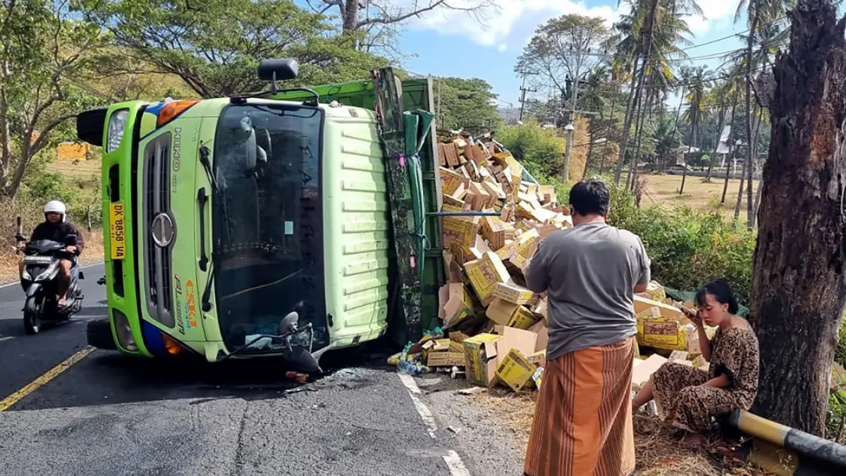 Truk tronton bermuatan minuman penyegar terguling di kawasan GWD, Desa Bangsring, Kecamatan Wongsorejo, Rabu pagi (22/7). (Ramada Kusuma/Radar Banyuwangi)