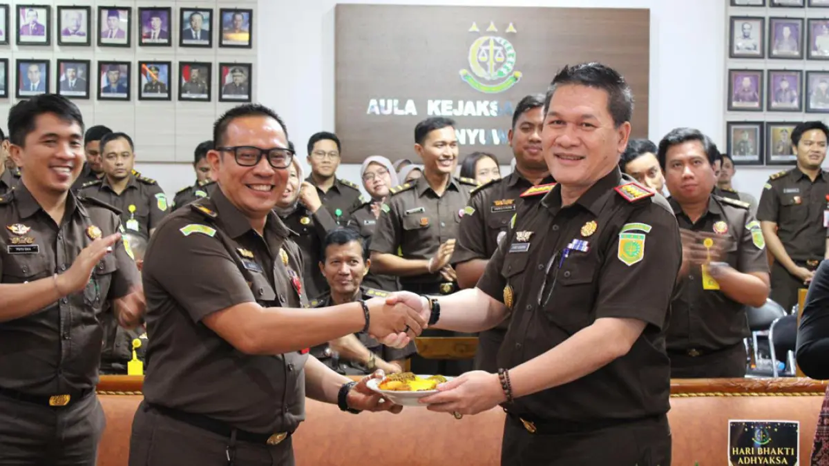 Kajari Banyuwangi, Farid Gunawan (kanan) memberikan potongan tumpeng kepada Kasi Pidum, Agus Haryono (kiri) dalam HBA ke-66 di Kejari Banyuwangi, Kamis (23/7). (Istimewa)