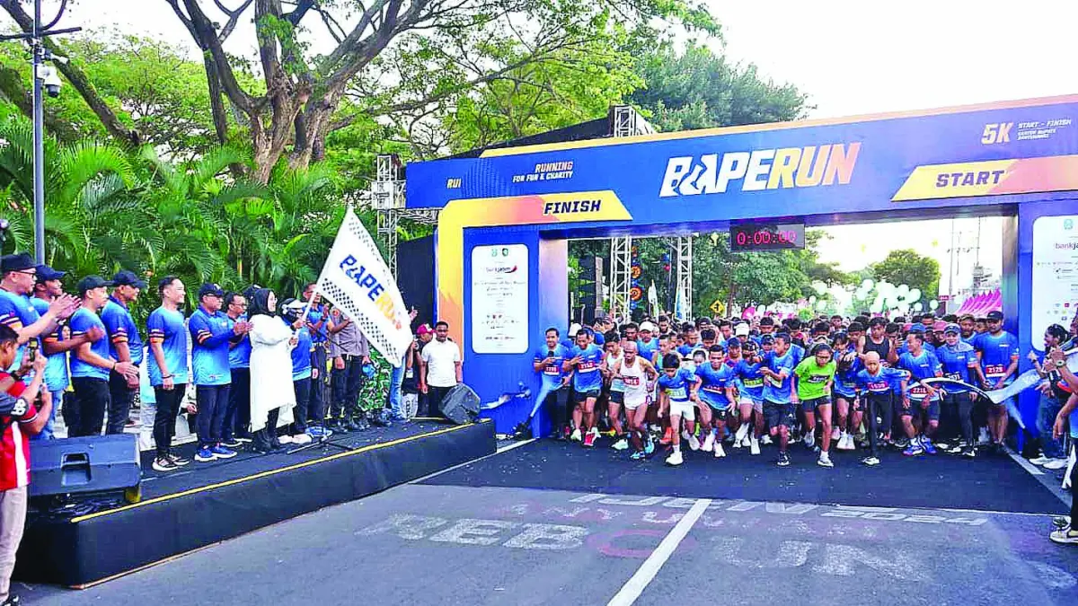 SEHAT-SEMANGAT: Bupati Ipuk Fiestiandani mengibarkan bendera start ajang BAPERUN 2026 di depan kantor Pemkab Banyuwangi Minggu (26/7). (RAMADA KUSUMA/RABA)