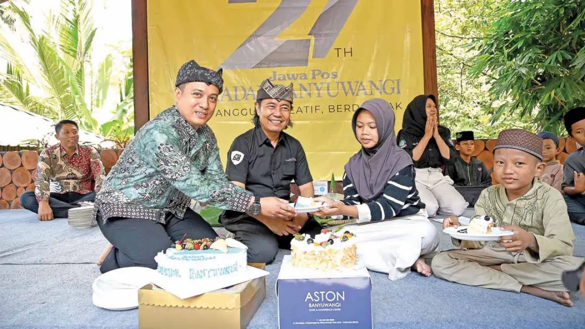 SIMBOL PERAYAAN: Camat Licin Licin Donny Arsilo Sofyan disaksikan Direktur JP-RaBa Samsudin Adlawi menyerahkan potongan kue tart kepada perwakilan anak yatim. (Ramada Kusuma/Radar Banyuwangi)