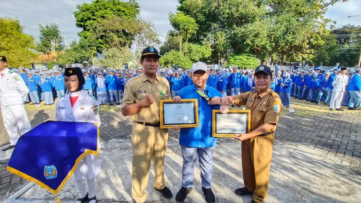 SERTIFIKAT: Yusril Ihsan Adinatanegara mendapat apresiasi dari Kepala SMAN 1 Glagah Abdullah (kanan) dan Kasubag Tata Usaha Cabang Dinas Pendidikan Provinsi Jatim Wilayah Banyuwangi Setyo Agung (kiri) saat upacara bendera Senin (27/7). (Toha/Radar Banyuwangi)
