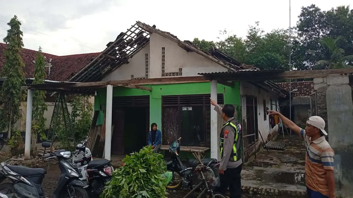 GENTING RONTOK: Anggota Polsek Purwoharjo meninjau rumah yang terdampak angin kencang di Dusun Ngadirejo, Desa Bukurejo, Kecamatan Purwoharjo, Minggu sore (27/7). (Foto: Agus Suhartono)