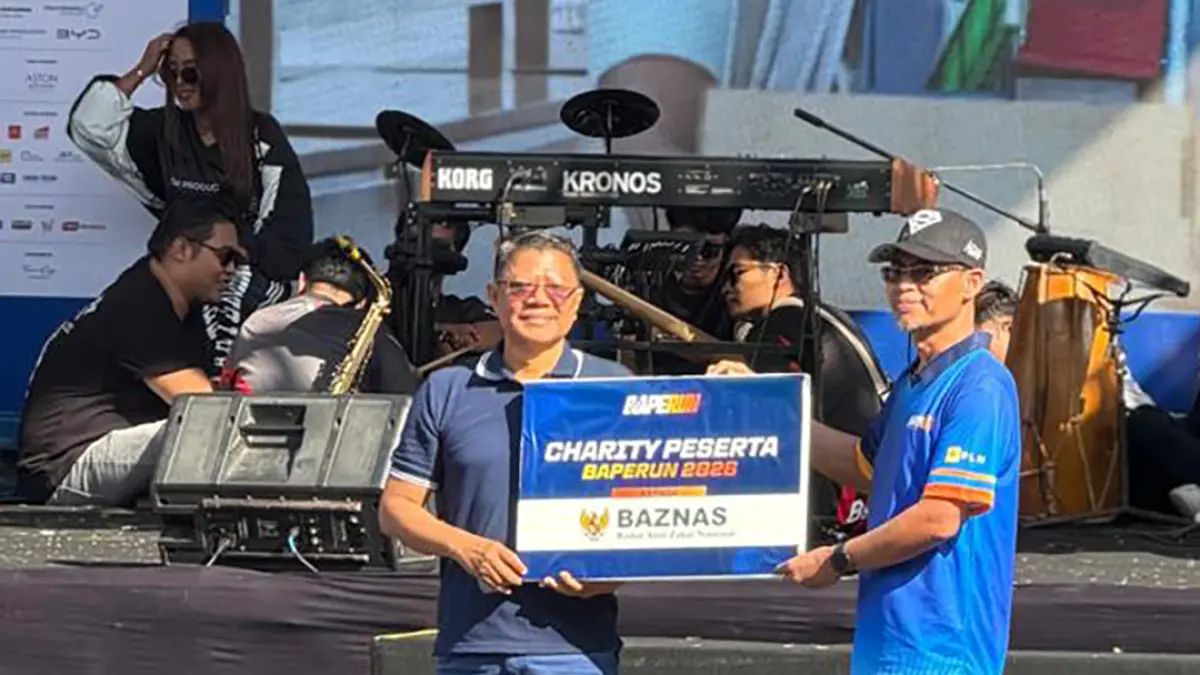 Ketua Baznas Kabupaten Banyuwangi Dwi Yanto (kiri)  menerima plakat charity dari Pelaksana Tugas Kepala Bapenda Kabupaten Banyuwangi Samsudin di panggung Baperun 2026, pada Minggu pagi (26/7/2026). (Dok. Bapenda)