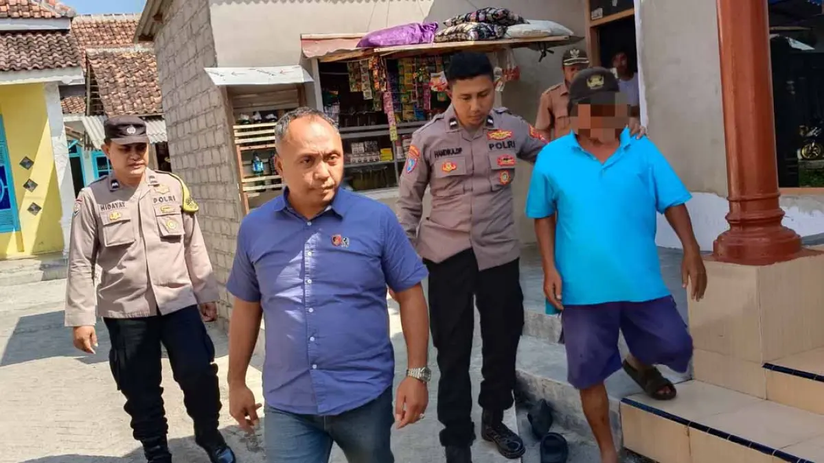 DIBAWA KE MAPOLSEK: Anggota Polsek Muncar mengamankan lansia yang menjadi  terduga pelaku pencabulan anak di Desa Kedungrejo, Kecamatan Muncar, Senin (27/7). (Foto: Polsek Muncar)