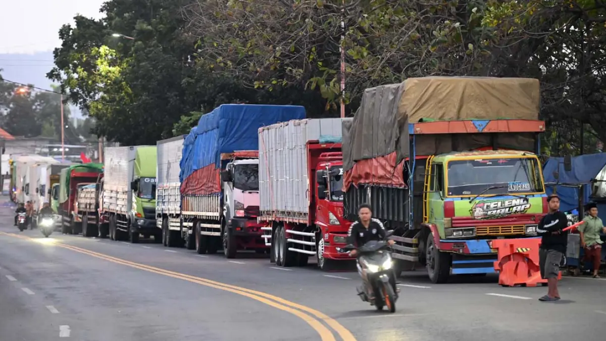 DAMPAK CUACA BURUK: Iring-iringan truk pengangkut logistik menuju Dermaga Bulusan mengular sampai jalan raya, Rabu (29/7). (Ramada Kusuma/Radar Banyuwangi)