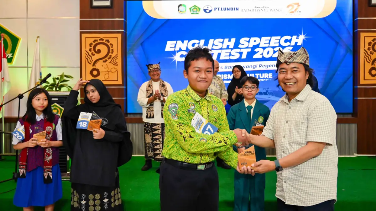JUARA 1: Siswa MTsN 1 Banyuwangi Laskhar Adelard Nawwafi Fahriyanto menerima piala dari Direktur JP-RaBa Samsudin Adlawi. (Ramada Kusuma/Radar Banyuwangi)