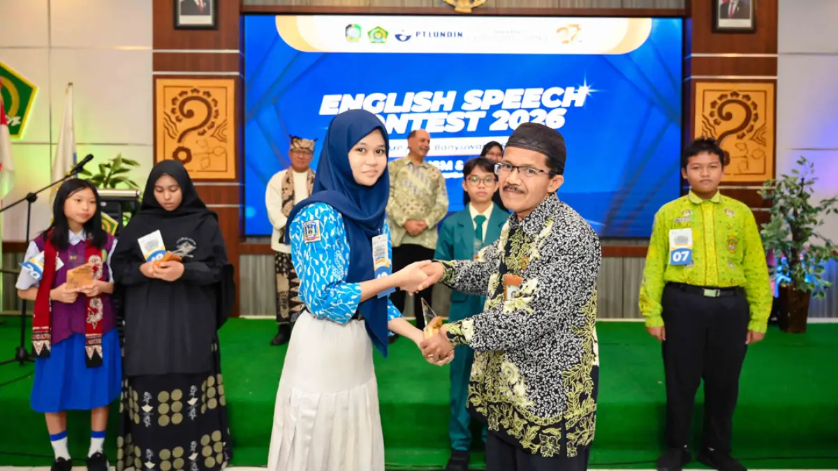 JUARA 2: Siswa SMPN 2 Banyuwangi, Cinta Putri Hendrawan, menerima piala dari Kasi Bimas Islam Kemenag Banyuwangi H. Mastur. (Ramada Kusuma/Radar Banyuwangi)