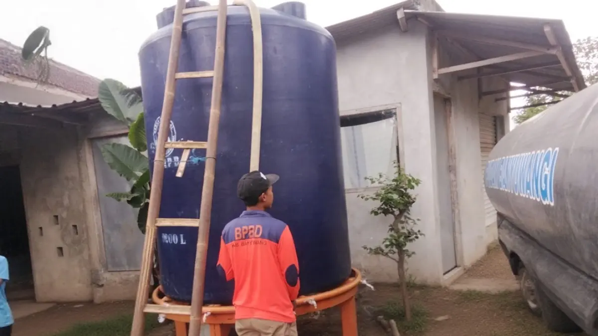 Petugas menyalurkan air bersih di Desa Kebondalem, Kecamatan Bangorejo, Jumat (31/7). (Ismanto for Radar Banyuwangi)