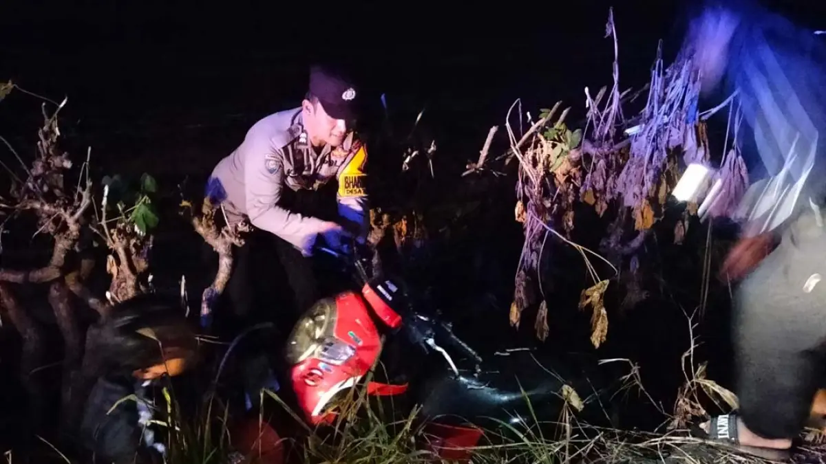 BANTUAN DATANG: Anggota Polsek Muncar membantu warga mengevakuasi seeda motor masuk parit di Desa Tembokrejo, Kecamatan Muncar, Minggu dini hari (2/8). (Dok. Polsek Muncar)