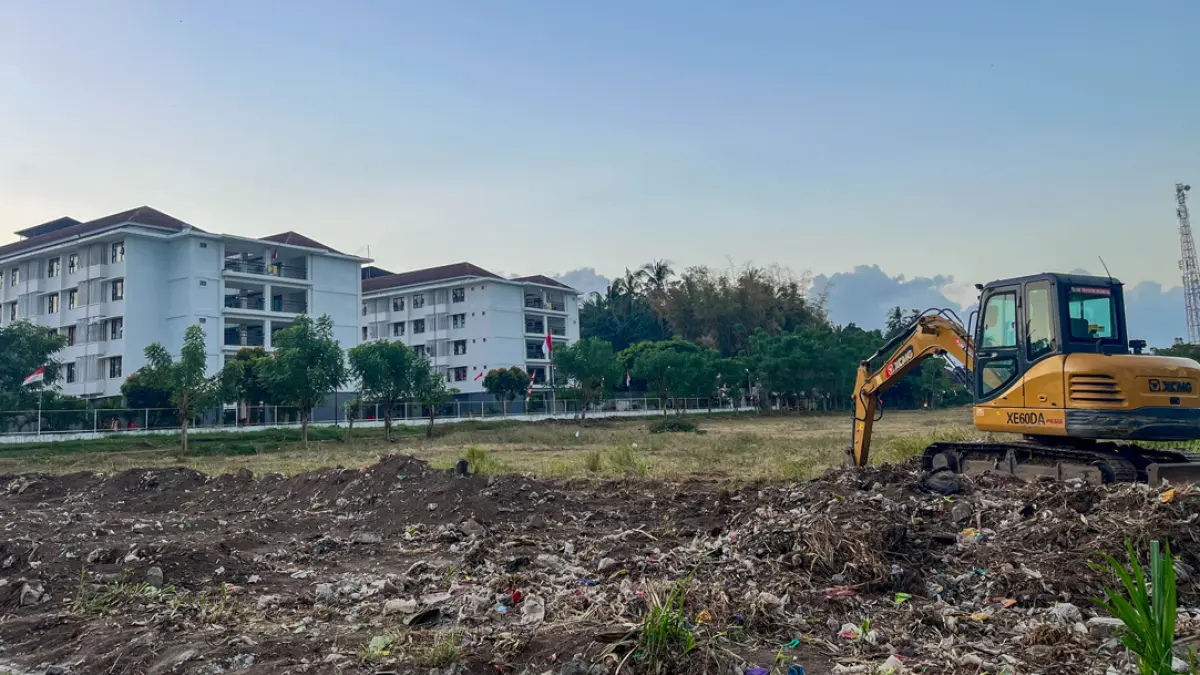 Alat berat mengeruk tanah yang akan dibangun KDKMP yang lokasinya di samping rumah susun sederhana sewa (rusunawa) Kelurahan Klatak, Kecamatan Kalipuro, Senin (3/8). (Ramada Kusuma/Radar Banyuwangi)