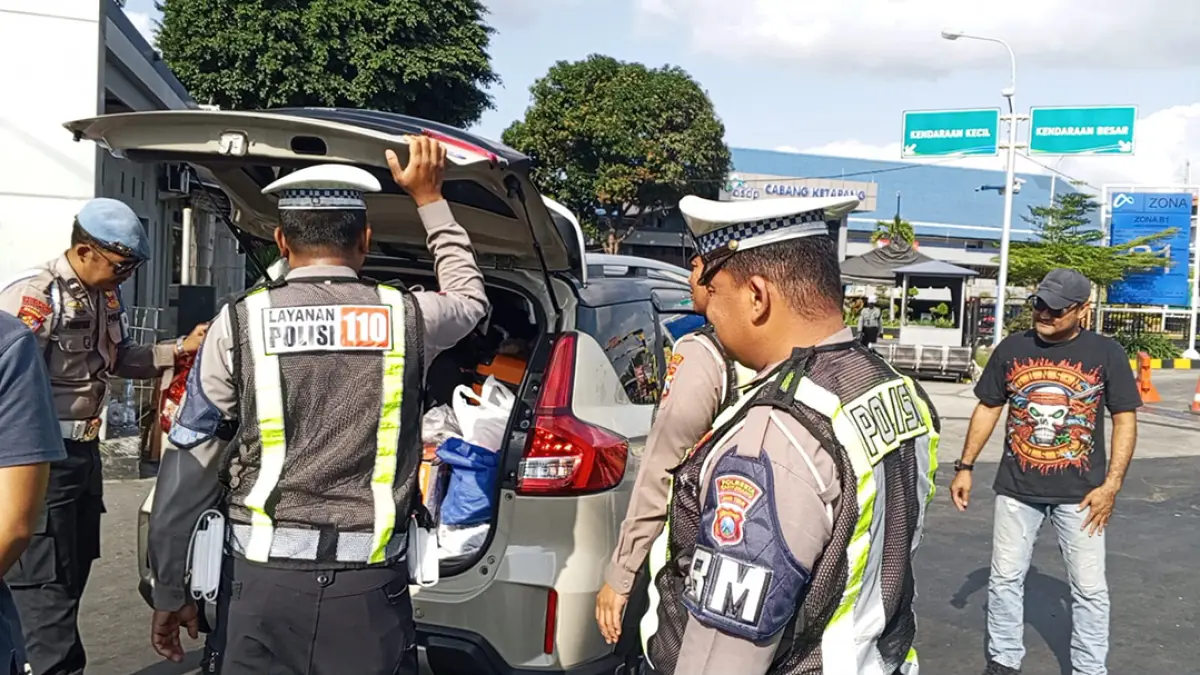 Anggota Satlantas Polresta Banyuwangi memeriksa surat kendaraan sopir ketika memasuki area Pelabuhan ASDP Ketapang, Selasa (4/8). (Ramada Kusuma/Radar Banyuwangi)