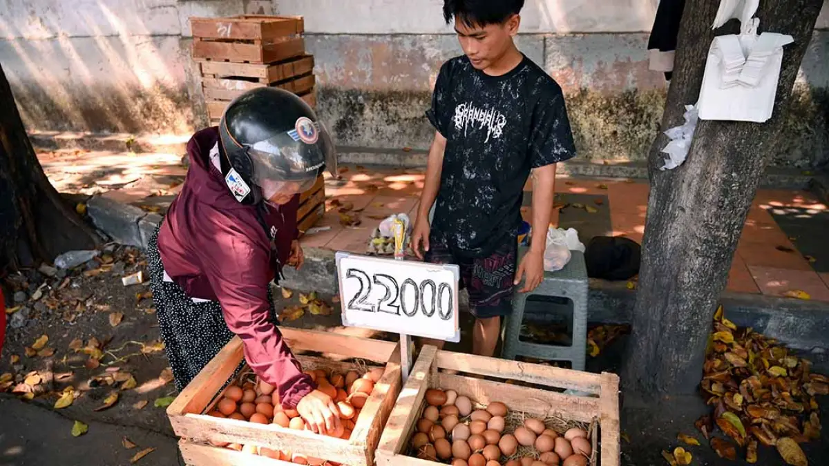 SEMPAT TURUN HARGA: Konsumen membeli telur ayam ras di lapak pedagang dadakan di kawasan Jalan MT Haryono Banyuwangi pada awal Juli lalu. (Ramada Kusuma/Radar Banyuwangi)