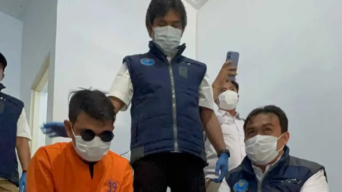 NF dikawal ketat anggota BNNK saat melihat proses penggeledahan di Perum Taman Argopuro Indah, Rabu (5/8). (Bagus Rio/Radar Banyuwangi)