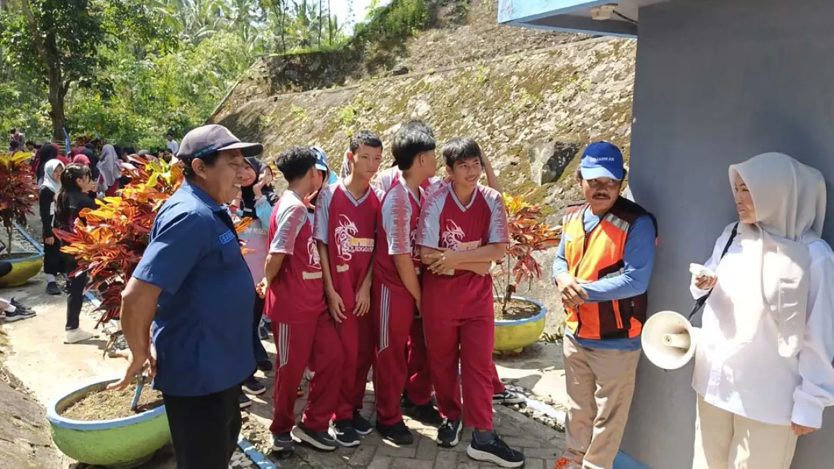 Pemateri dari PUDAM Banyuwangi Nadia (baju putih) saat memberi materi tentang sejarah Sumber Gedor ditemani Slamet (rompi oranye) selaku penjaga bangunan sumber peninggalan Belanda tersebut Rabu (5/8). Ksatria Raya/Radar Banyuwangi)