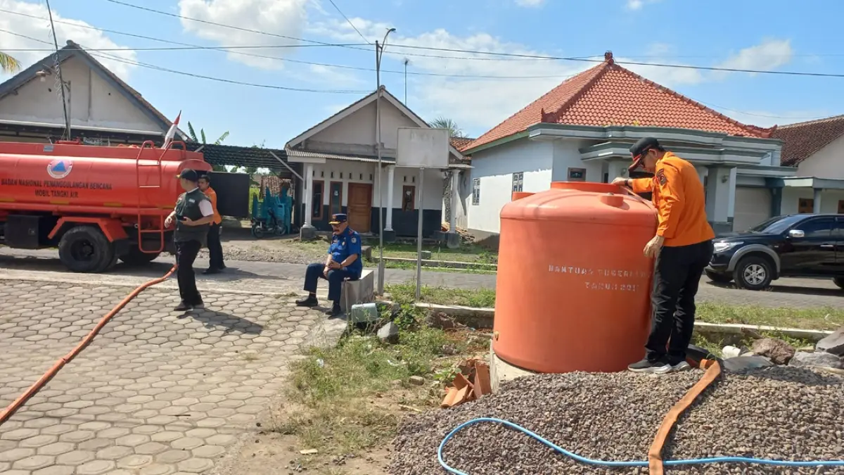 BANTUAN DATANG: Petugas BPBD Banyuwangi menyalurkan air bersih kepada warga di Kecamatan Tegaldlimo Jumat (7/8). (Trisetya for Radar Banyuwangi)