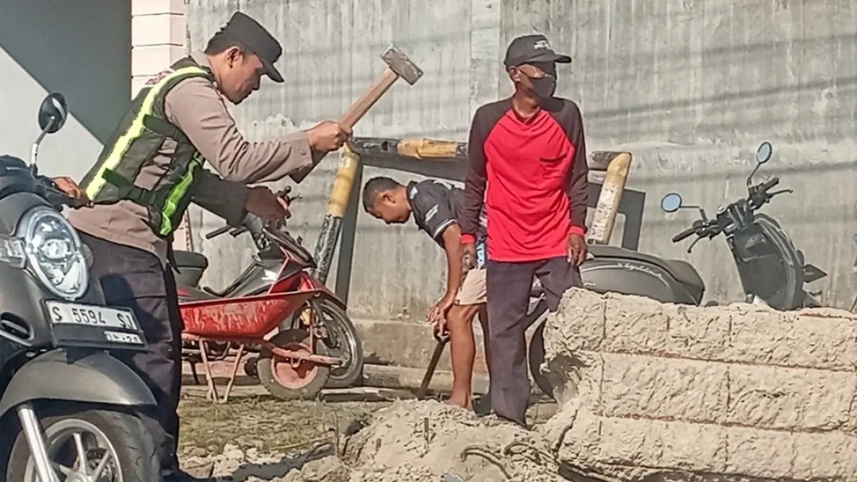 Bhabinkamtibmas Desa Tembokrejo Aiptu Junaidi Efendi bersama warga membongkar portal di Simpang Empat Dusun Palurejo, Desa Tembokrejo, Kecamatan Muncar, Jumat (7/8). (Polsek Muncar for Radar Banyuwangi)
