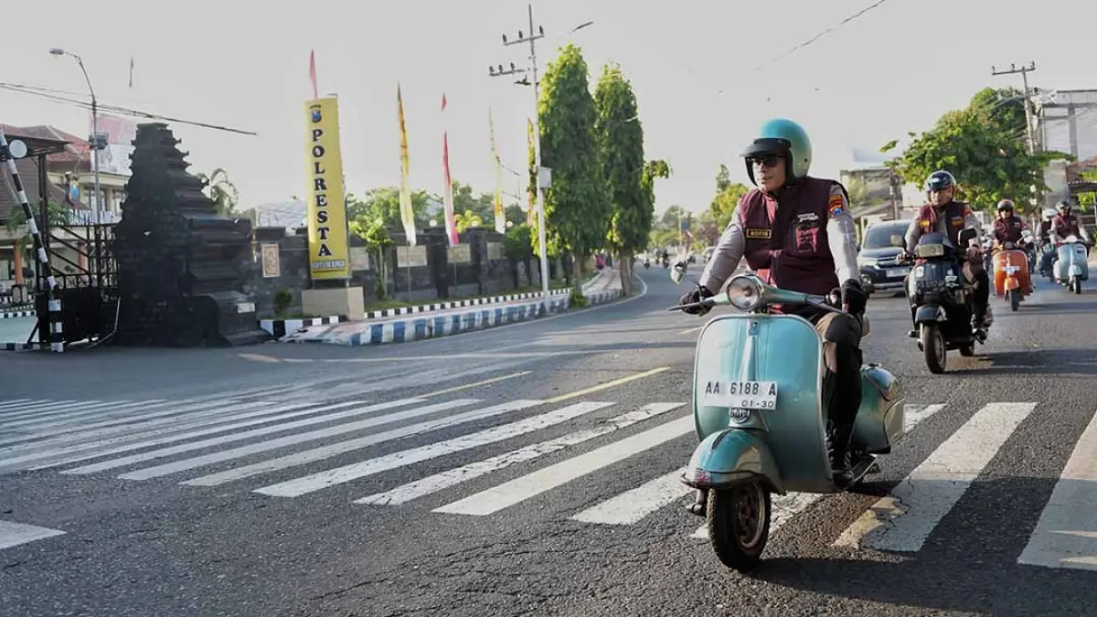 Kapolresta Banyuwangi Kombespol Rofiq Ripto Himawan mengendarai Vespa nopol AA 6188 A menuju Polsek Banyuwangi Kota dan Kalipuro, Jumat (7/8). (Humas Polresta Banyuwangi)