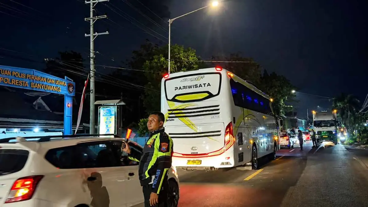 URAI ANTREAN: Petugas Satlantas Polresta Banyuwangi mengatur kendaraan di depan Mako Satpolair Banyuwangi Sabtu (8/8) malam. (Polsek Tanjungwangi untuk Radar Banyuwangi)
