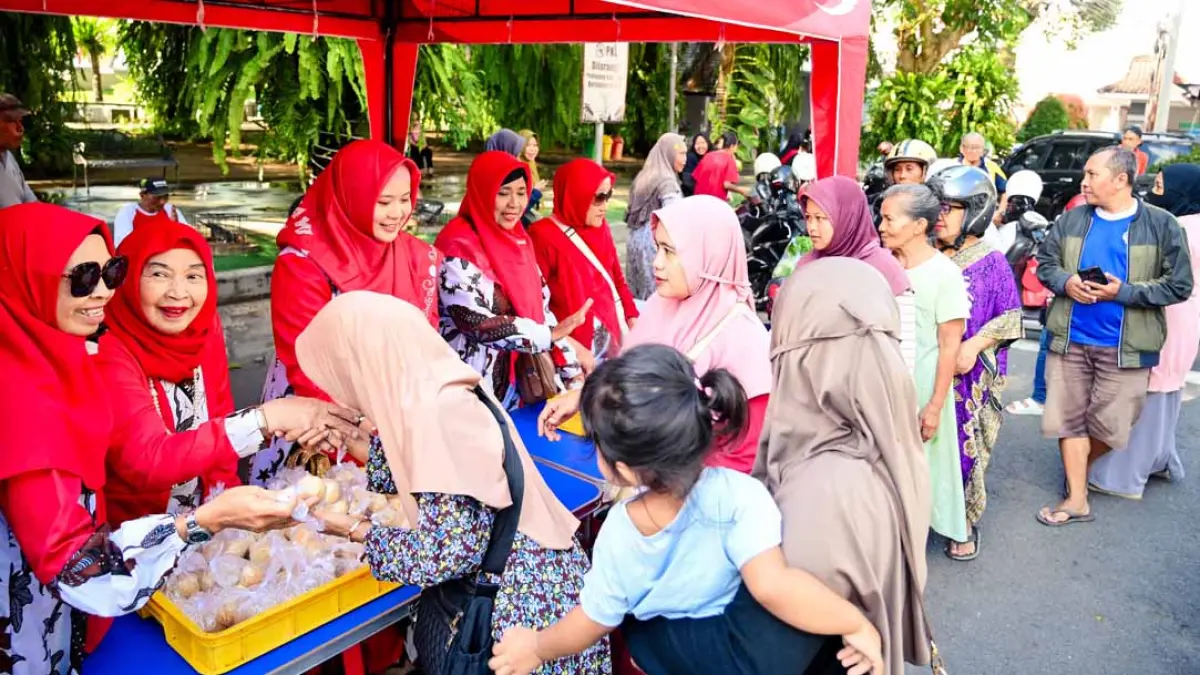AKSI SOSIAL: Bu Pur membagikan onde-onde hangat kepada pengguna jalan yang melintas di depan TMP Wisma Raga Satria, kemarin (10/8). (Ramada Kusuma/Radar Banyuwangi)