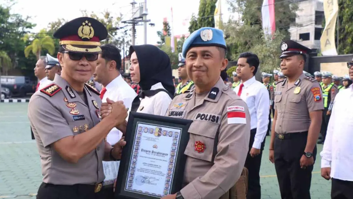 Kapolresta Banyuwangi Kombespol Rofiq Ripto Himawan menyerahkan penghargaan kepada Aipda Lukman Hakim anggota Bag SDM karena telah menjalankan tugas sebagai IPO dalam misi PBB Minusca di Republik Afrika Tengah selama dua tahun. (Humas Polresta Banyuwangi)