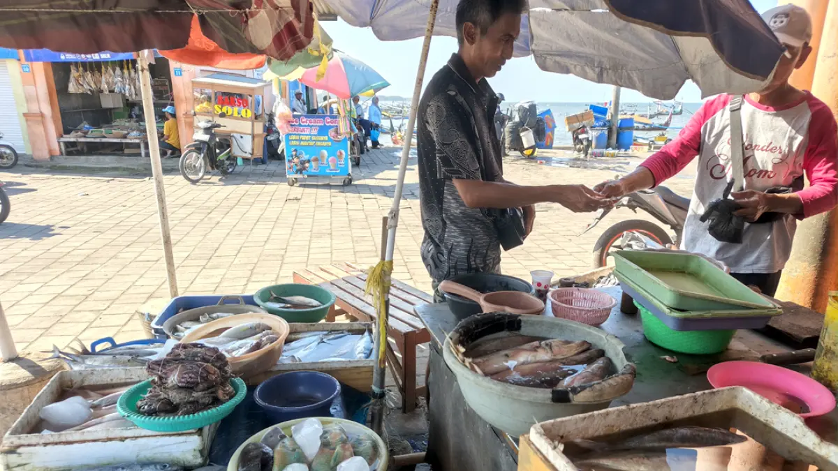 JUAL BELI: Penjual ikan di Pasar Brak Kalimoro, Desa Kedungrejo, Kecamatan Muncar sedang melayani pembeli Senin (10/8). (Zamrozi Wahyu/Radar Banyuwangi)