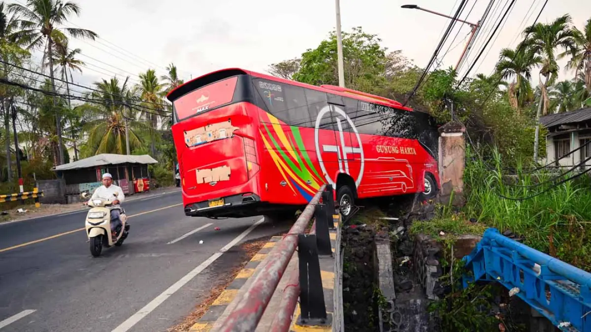 NANGKRING: Bus Gunung Harta nopol DK 7018 GH menabrak pembatas jalan di sebelah selatan jembatan Klatak, pukul 00.30 Senin dini hari (10/8). (Ramada Kusuma/Radar Banyuwangi)