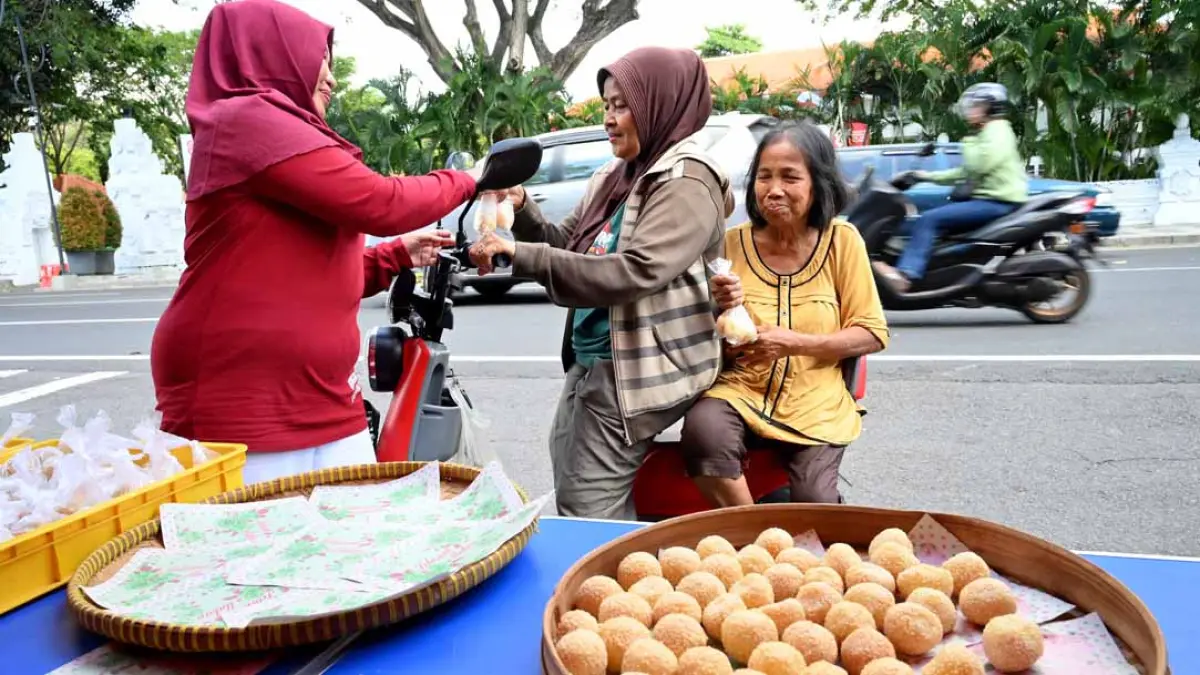 Pengguna jalan dan warga di sekitar TMP Wisma Raga Satria berbaris rapi mendapatkan onde-onde gratis yang disiapkan Bu Pur. (Ramada Kusuma/Radar Banyuwangi)