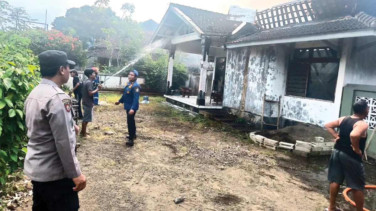 BERJIBAKU: Petugas Damkarmat melaksanakan tugas memadamkan kebakaran di Dusun Krajan 2, Desa Tampo, Kecamatan Cluring, Selasa (11/8). (Zamrozi Wahyu/Radar Banyuwangi)