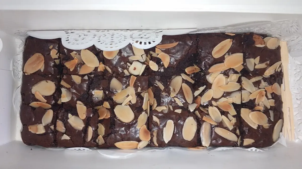 Fudgy brownies dengan lapisan shiny crust yang mengilap dan retak. Teknik pencampuran bahan serta pengaturan suhu oven menjadi kunci untuk menjaga permukaan renyah tipis dan bagian dalam tetap lumer. (Meivira untuk Radar Banyuwangi)