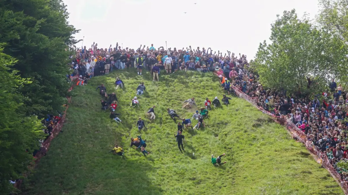 Peserta Cheese Rolling berusaha mengejar roda keju yang meluncur dari puncak Cooper’s Hill, Gloucestershire, Inggris. Tradisi ekstrem ini tetap digelar dan menarik peserta serta wisatawan dari berbagai negara. (Backpacking Peanuts)
