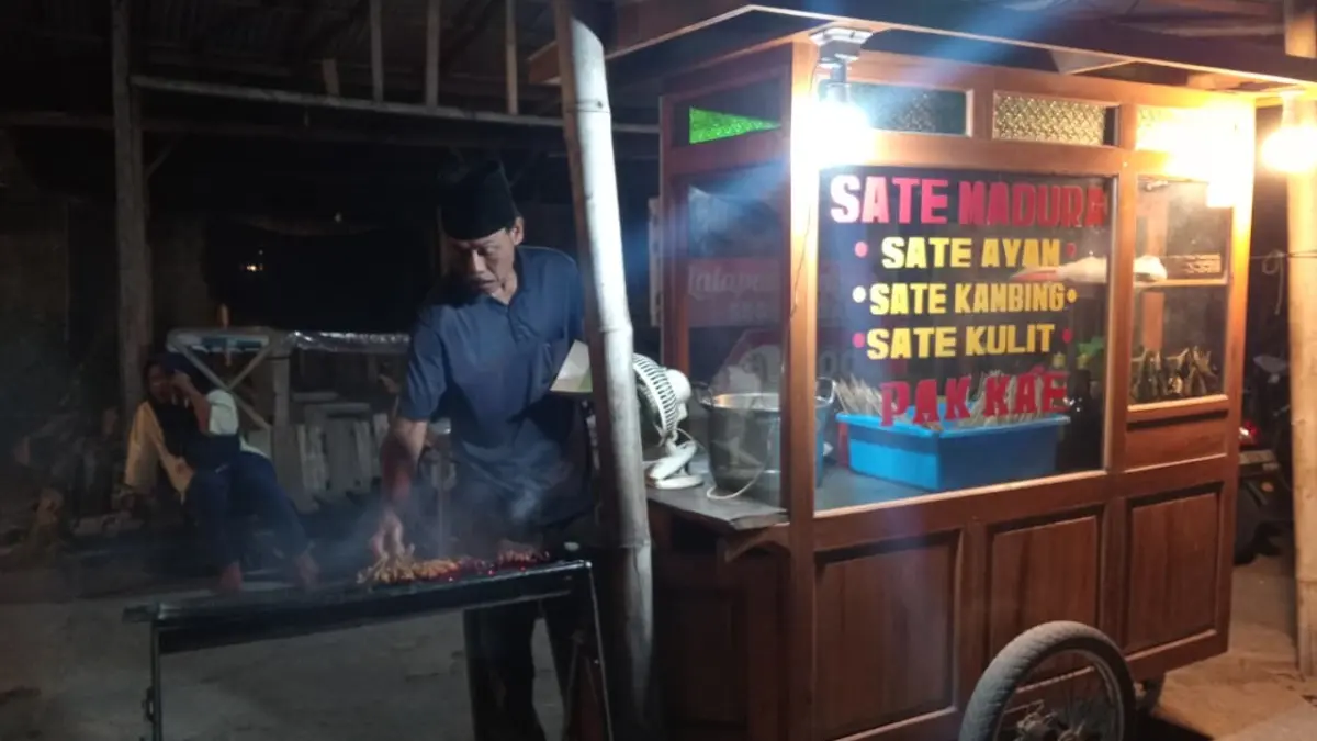 Sate ayam dan varian lainnya dibakar langsung di atas arang di Sate Madura di Banyuwangi. Aroma asap menjadi salah satu daya tarik sajian kuliner malam tersebut. (Balquisse untuk Radar Banyuwangi)