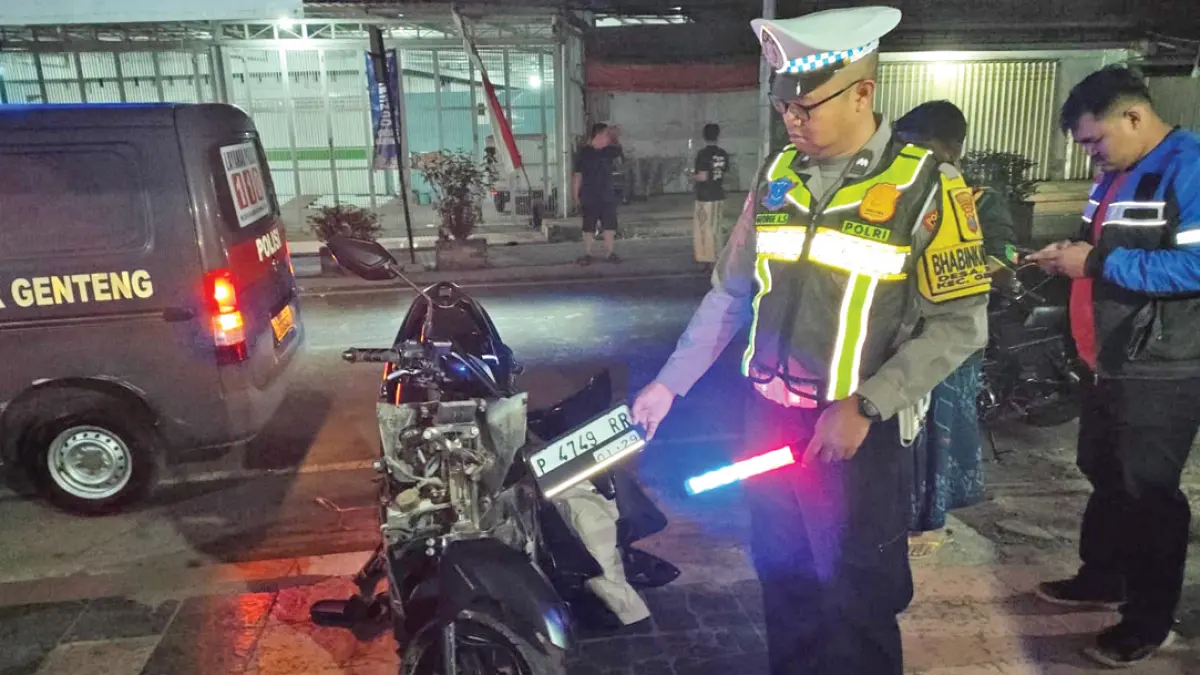 Anggota Polsek Genteng menunjukkan sepeda motor yang mengalami kecelakaan di Jalan Gajah Mada, tepatnya di depan Gereja Efrata, Desa Gentengkulon, Kecamatan Genteng, Rabu malam (12/8). (Polsek Genteng for Radar Banyuwangi)