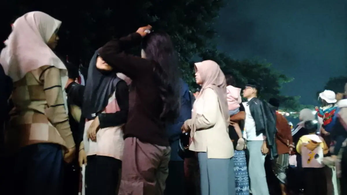 Penonton berdiri di tepi jalan saat karnaval berlangsung. Antusiasme menyaksikan peserta dari jarak dekat kerap membuat pandangan penonton di barisan belakang ikut terhalang. (Meivira untuk Radar Banyuwangi)