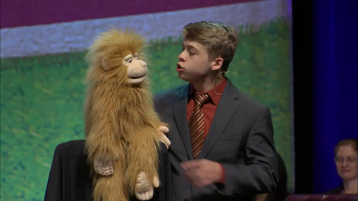 Ventriloquist tampil bersama boneka dalam pertunjukan yang mengandalkan ilusi suara, akting, dan kemampuan mengendalikan gerakan bibir. (YouTube/ACE School of Tomorrow)