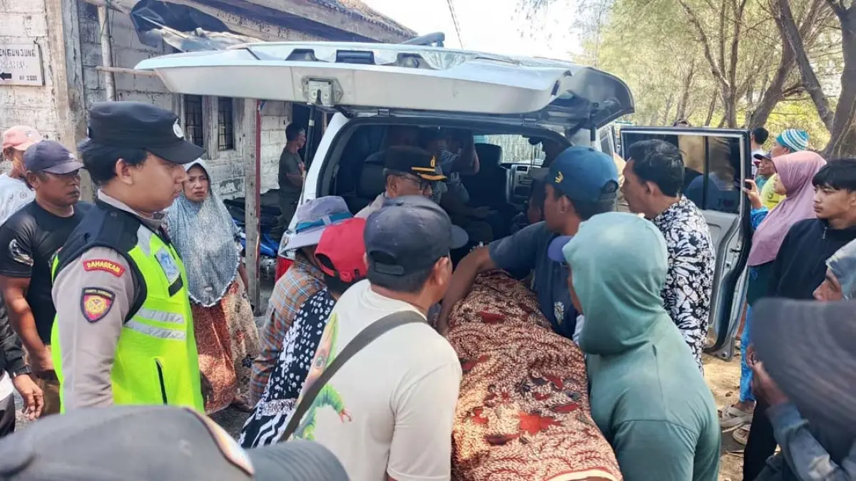 Anggota Polsek Rogojampi menangani pria yang ditemukan meninggal dunia di Pantai Kompit, Dusun Glondong, Desa Watukebo pada Kamis (13/8). (Kompol Imron for Radar Banyuwangi)