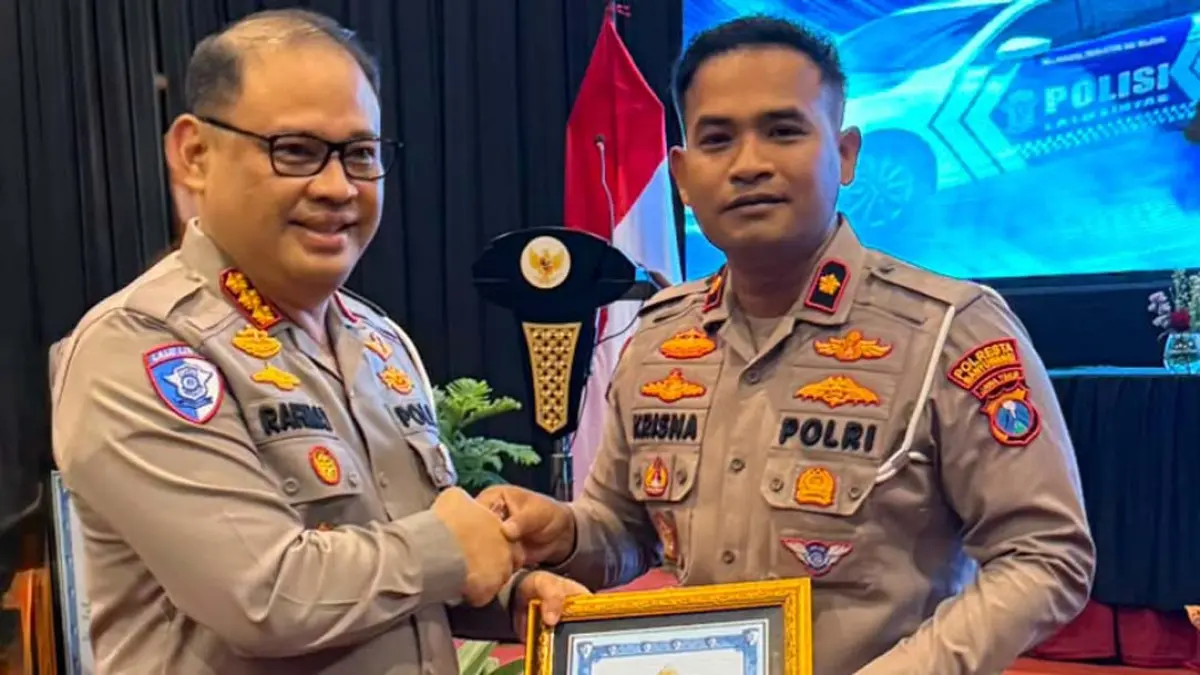 Dirlantas Polda Jatim Kombespol Rahmat Hakim menyerahkan penghargaan kepada Kasat Lantas Polresta Banyuwangi Kompol I Gusti Bagus Krisna Fuady (kanan) di Hall Batu Suki Resort & Hotel, Kota Batu, Jumat (14/8). (Satlantas Polresta Banyuwangi)
