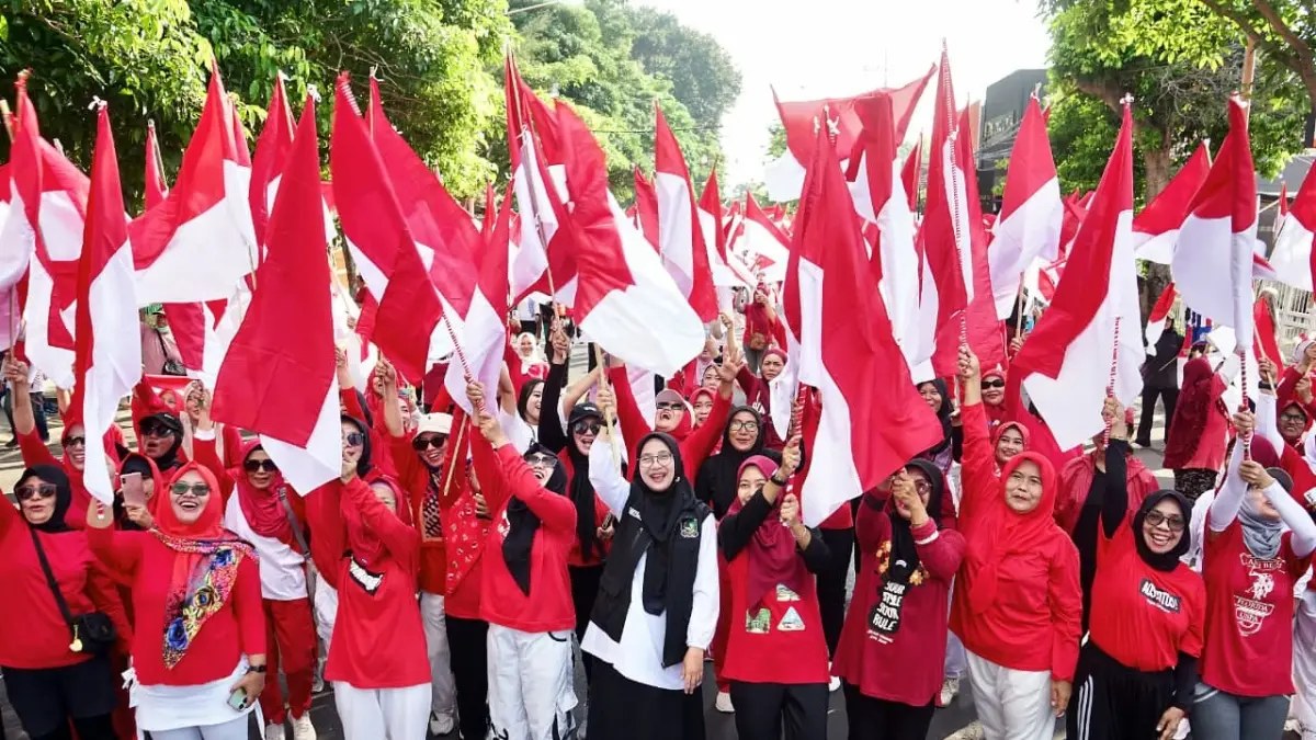 Bupati Banyuwangi Ipuk Fiestiandani membagikan bendera Merah Putih gratis kepada warga saat CFD di Jalan A. Yani, Minggu (16/8). (Portal Banyuwangi)