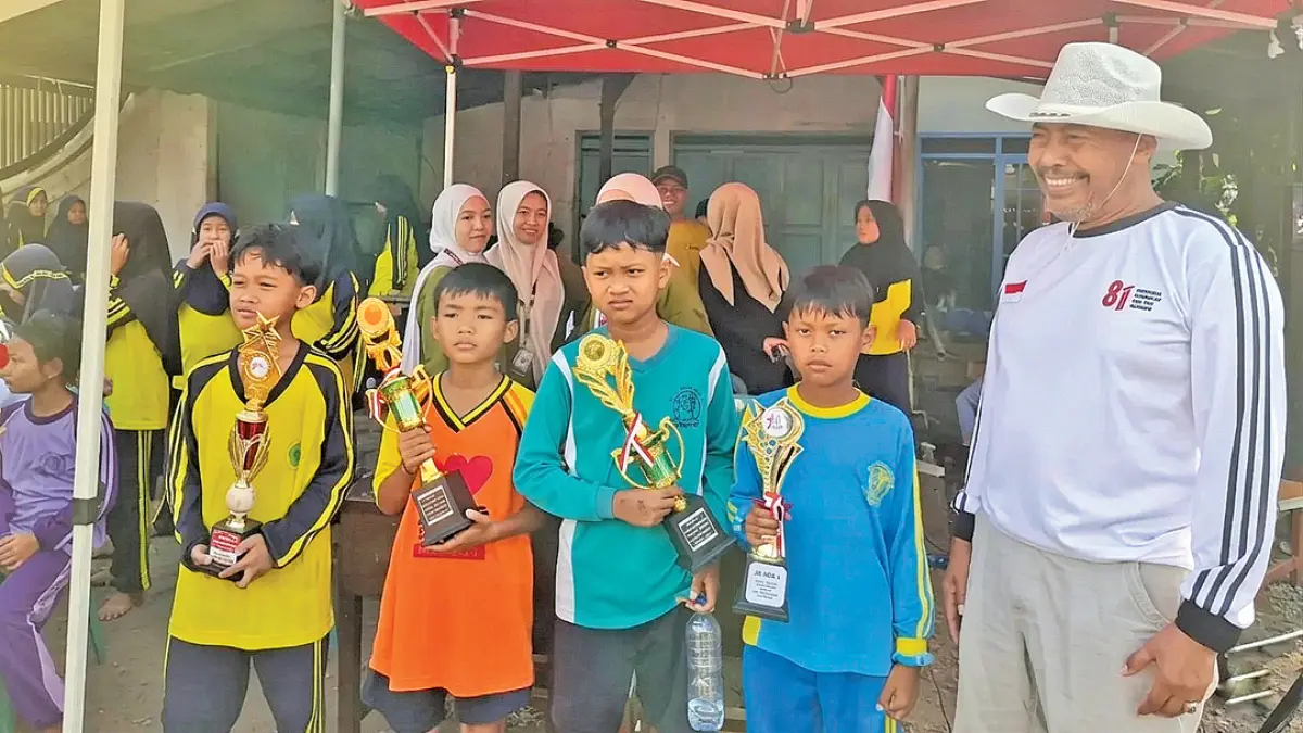 GENERASI PENERUS: Muadim menyerahkan hadiah kepada pemenang lomba lari peringatan HUT ke-81 RI di Desa Wringinrejo, Kecamatan Gambiran. (Muadim for Radar Banyuwangi)