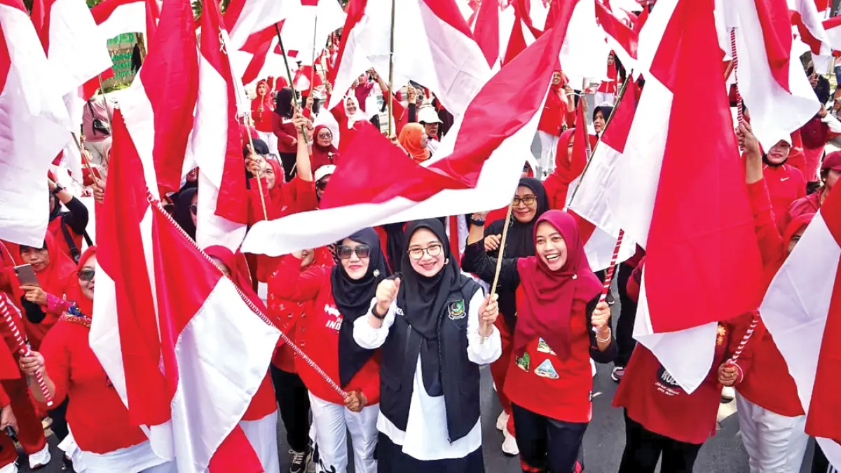 NUANSA KEMERDEKAAN: Bupati Ipuk Fiestiandani mengibarkan bendera merah putih bersama warga di lokasi CFD Jalan Ahmad Yani Banyuwangi, Minggu (16/8). (Humas Pemkab Banyuwangi)